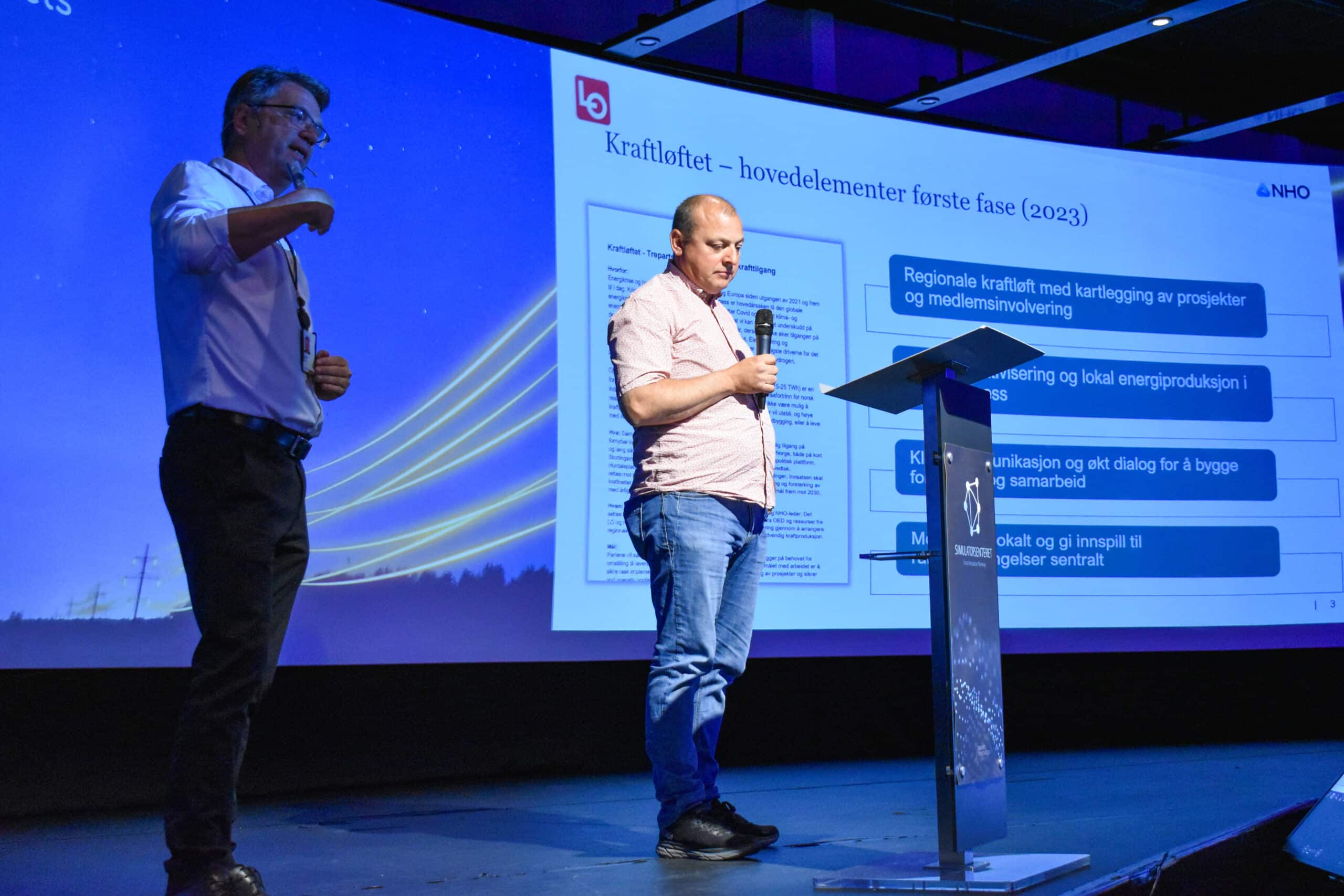Jon-Vidar Knold (t.v., NHO Oslo Viken) og Ulf Lervik, LO Østfold, står på scenen i Smart Innovation Arena under energiseminaret 1. juni 2023.